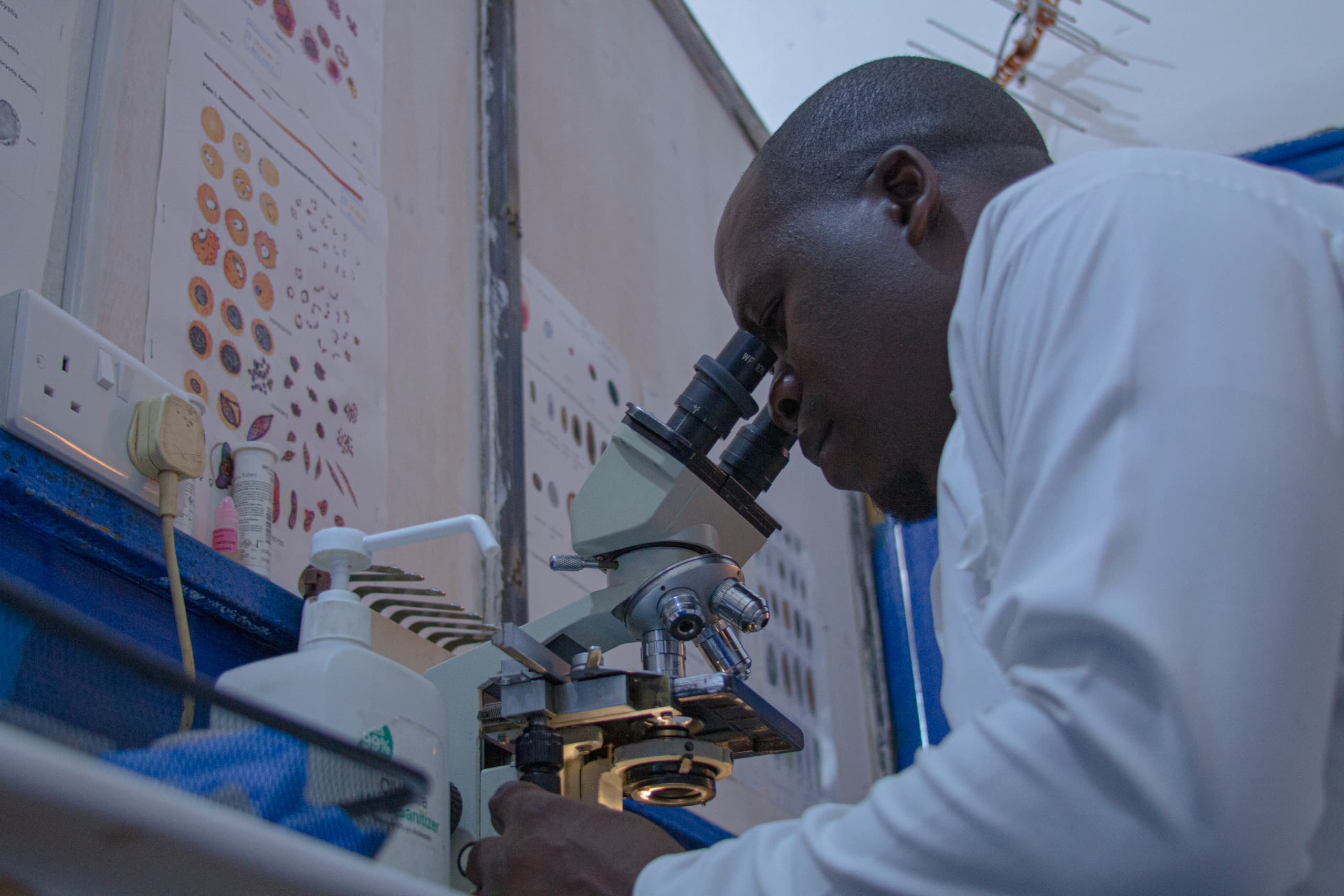 A Mysha laboratory technician examining a sample under the microscope